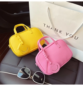 Detail showing colorful litchi texture pillow bags with smiley face charms on car seat