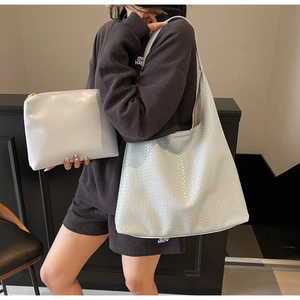 Detail showing woven texture tote bag set with matching small zipper pouch in off-white