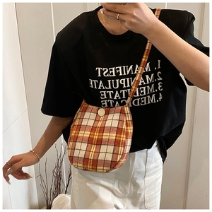 Close-up of orange and yellow plaid cross-body bag with round button closure
