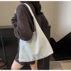 Detail of minimalist woven texture and large capacity design on white shoulder tote bag