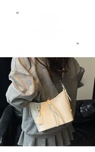 Détail d'un sac seau en cuir blanc crème avec boucle métallique et bandoulière chic