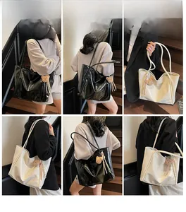 Detail of glossy leather tote bags in black and cream white with cute bear charms