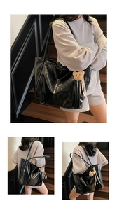 Detail of black oil-wax leather tote bag featuring a cute brown plush bear charm and tassel