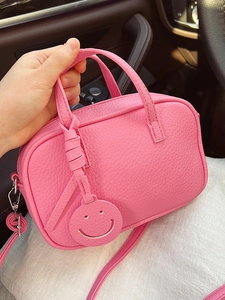 Pink lychee grain leather pillow bag with double handles and a cute smiley face pendant
