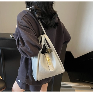 Détail du sac à main gris argenté en cuir grainé avec fermoir métallique doré chic