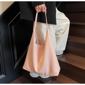 Detailed view of pink woven texture on large capacity tote bag with smooth faux leather finish