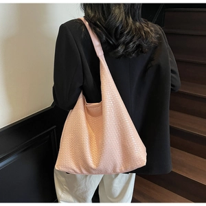 Pink woven hobo tote bag worn by model in a stylish office commuter setting