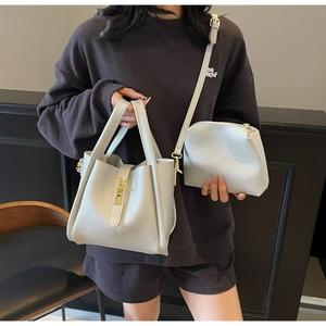Détail du sac à main beige grainé avec pochette assortie et boucles dorées chic