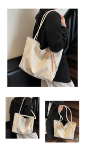 Close-up of cream oil wax leather tote bag with cute bear charm and tassel detail