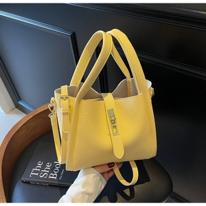 Détail du sac jaune motif litchi avec fermoir pivotant en métal et bandoulière chic