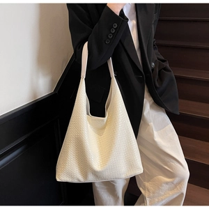 Detail of cream white woven tote bag showing large capacity and hobo silhouette