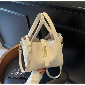 Détail du sac à main en cuir litchi blanc avec boucle en métal doré et texture riche