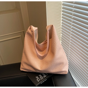 Detail of pink woven leather tote bag showing intricate texture and luxury hobo style