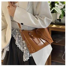 Détail d'un sac seau en cuir ciré marron avec boucle latérale et bandoulière réglable