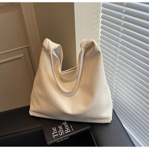Detail of premium woven leather texture on a cream white large capacity tote bag