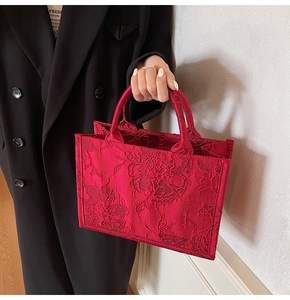 Close-up of elegant red bridal tote bag featuring intricate floral embroidery details