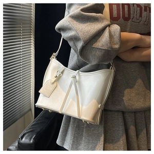 Détail du sac hobo en cuir ciré blanc avec cordon noué et pieds de protection
