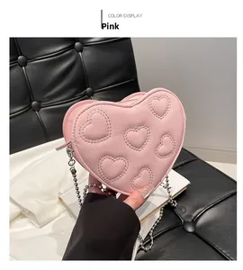 Detailed view of the pink heart-shaped bag featuring embossed patterns and bead chain