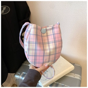 Detail of pink and purple plaid fabric bag with round blue button and snap closure