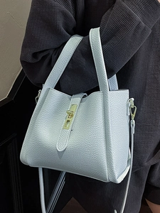 Sac seau bleu clair en cuir grainé avec fermoir doré porté en bandoulière pour femme