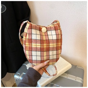 Detail of vintage plaid canvas bag featuring checkered pattern and decorative round button