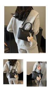 Detail of black woven texture bucket bag with cute bear charm and detachable strap