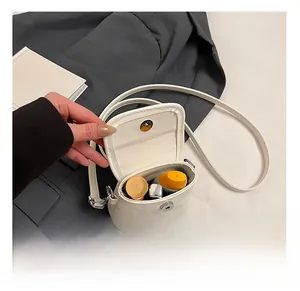 Detail view of mini white crossbody bag interior with magnetic snap button closure