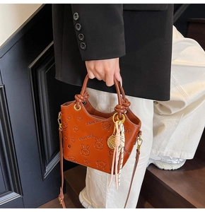 Detailed macro view of embossed retro leather bucket bag with cute cartoon patterns