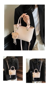 Detail of pink bucket bag with geometric texture, knotted handle and teddy bear charm