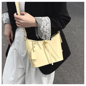 Sac seau blanc crème à la mode sur un modèle avec un style bandoulière en cuir minimaliste