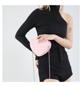 Pink heart-shaped patent leather crossbody bag with embossed patterns and silver chain