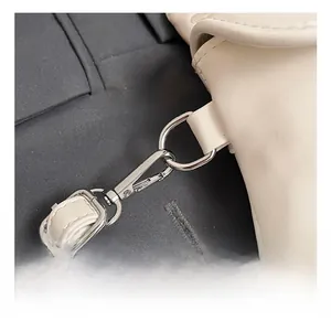 Detail of silver-tone lobster clasp and D-ring hardware on a cream leather phone bag