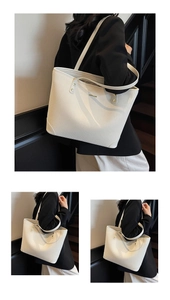 Detail view of the cream-white tote bag featuring textured woven pattern and gold logo plaque