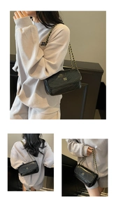 Detail view of black quilted leather shoulder bag with gold chain strap and metal logo