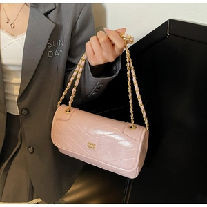 Close-up of pink oil wax leather crossbody bag with V-shaped stitching and gold chain