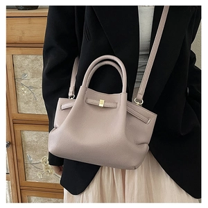 Detail of dusty pink bucket bag showing lychee grain texture and gold square buckle closure