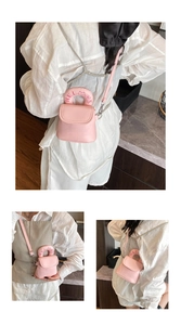 Pink mini crossbody bag featuring embroidery handle detail and matte leather flap design