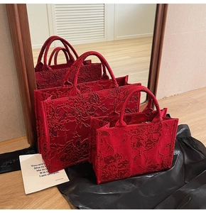 Detailed relief floral embroidery on red velvet bridal tote bags in two sizes