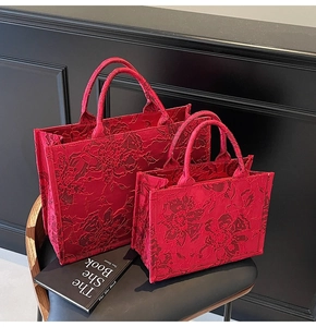 Detail of red bridal tote bags with 3D floral embroidery and dual handle design