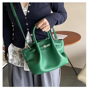 Detail view of the green leather tote bag with soft pleats and gold-tone hardware buckles