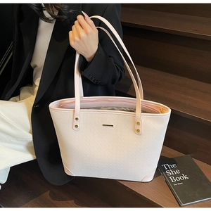 Detailed view of woven texture and gold bar logo on a large pink tote bag for women