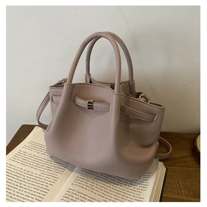 Detailed close-up of pink bucket bag with lychee texture leather and gold metal hardware