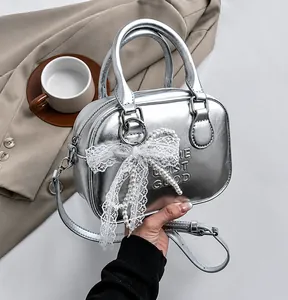 Detail of silver metallic bowling bag with Life Is Good embossing and pearl bow charm