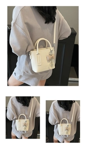 Detail der Eimer-Handtasche aus Litschi-Leder mit Perlenherz-Anhänger und Schleife