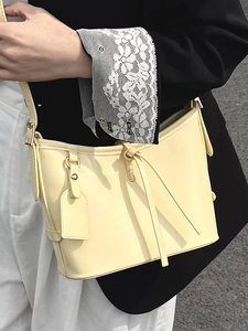 Sac seau croissant jaune clair avec nœud en cuir élégant et détails métalliques dorés