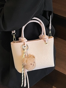 Pink woven bucket handbag with bear charm and detachable shoulder strap for daily casual use