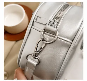 Macro detail of the silver metallic bowling bag showing premium hardware and side D-ring
