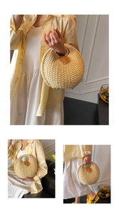 Detail view of woven straw shell bag with leather closure and metal feet in warm beige tone