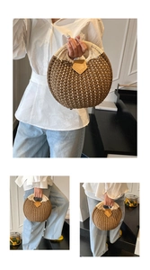 Detail of round straw handbag featuring woven brown and beige pattern with circular handles