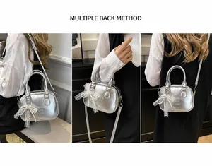 Detail of silver metallic mini bag featuring pearl bow and Time Just Good embossing